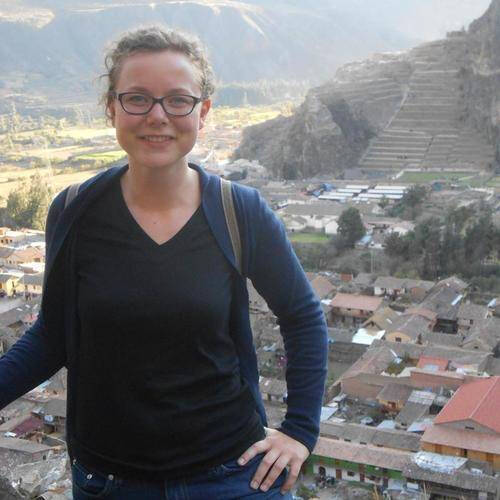 Alumna Caitlin Smith standing in front of a city
